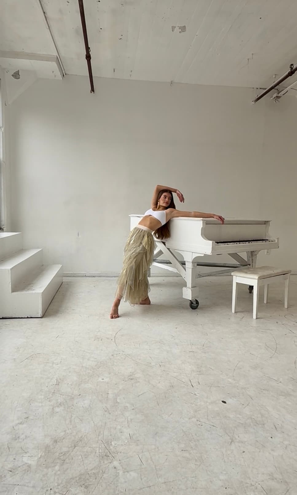 Chloe Marino posing beside a white piano